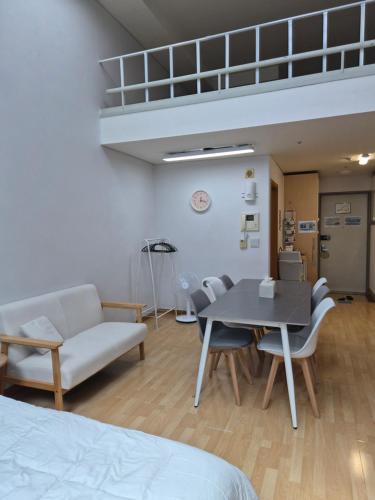 a room with a bed and a table and chairs at Hongdae Home Sweet Home in Seoul