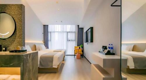 a hotel room with two beds and a mirror at Airfeel Hotel in Ziyang