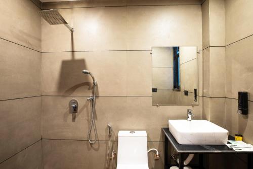a bathroom with a shower and a toilet and a sink at Aarchh Regency Noida in Noida