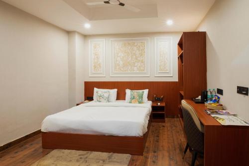 a bedroom with a bed and a desk with a desk at Aarchh Regency Noida in Noida