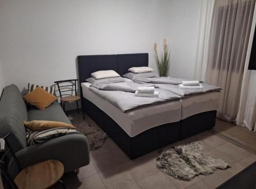 a bedroom with a large bed and a couch at Apartment and Room Mare Vrlika in Maovice