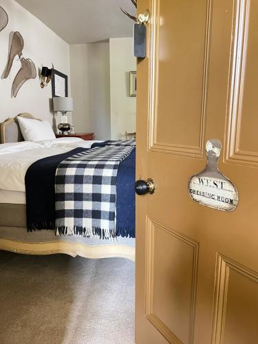 a bedroom with a bed with a black and white blanket at Uplands Guest House in Ledbury