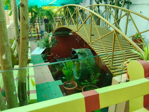 a view of a garden with plants and a bridge at Maha Periyava Kuteeram in Kumbakonam
