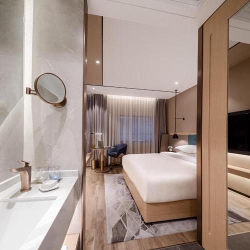 a hotel room with a bed and a bath tub at ZMAX Hotels Shenzhen Lianhuacun Metro Station in Shenzhen