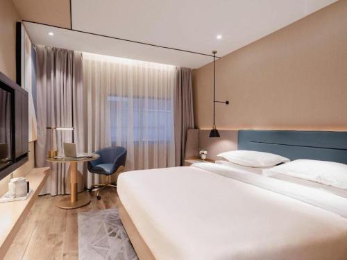 a hotel room with a large bed and a television at ZMAX Hotels Shenzhen Lianhuacun Metro Station in Shenzhen