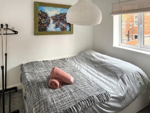 a bedroom with a bed with a pink towel on it at Number Two in Bridlington