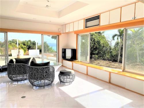 a living room with two chairs and a tv at Ie shima-MONKEY - Vacation STAY 48431v in Ie