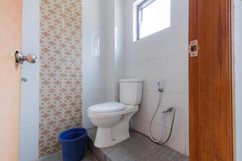 a bathroom with a toilet and a window at RedDoorz near Taman Rekreasi Selecta in Malang