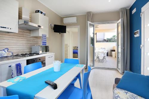 una cucina e una sala da pranzo con tavolo e sedie blu di Marea Sicula Home a Siracusa