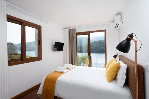 a bedroom with a large bed with a window at Casas do Picoto - Gerês Nature and Natural River Beach in Terras de Bouro
