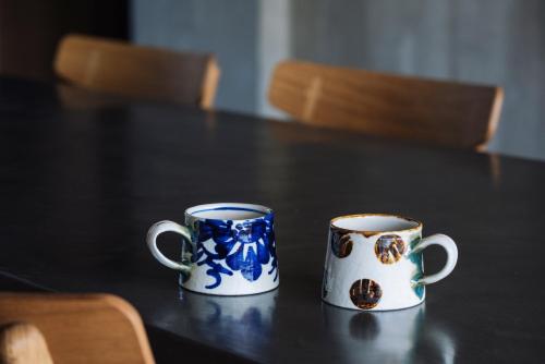 two blue and white mugs sitting on a table at 水と風 in Kumejima