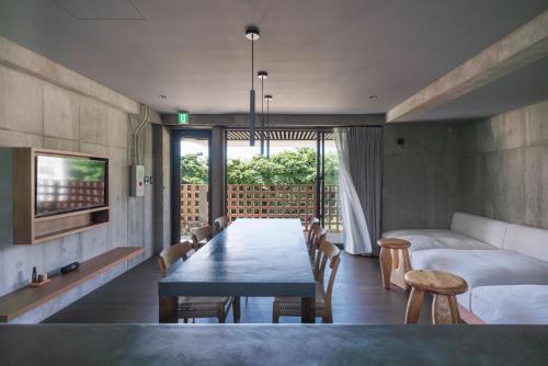 a living room with a table and a bed at 水と風 in Kumejima