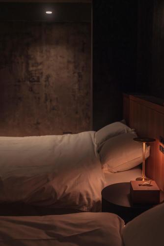 a bedroom with a bed and a table with a lamp at 水と風 in Kumejima