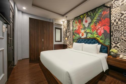 a bedroom with a large white bed and a floral wall at Elegance Premium Hotel in Hanoi
