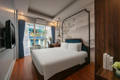 a bedroom with a large white bed and a window at Elegance Premium Hotel in Hanoi