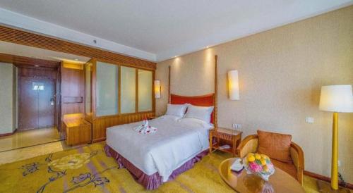 a hotel room with a bed and a table at Ocean Spring Metropark Hotel Zhuhai in Zhuhai