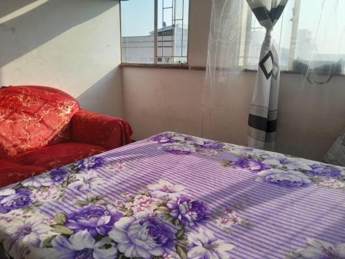 a bed with a purple blanket with flowers on it at 160 West Pietermaritzburg Sanethub in Pietermaritzburg