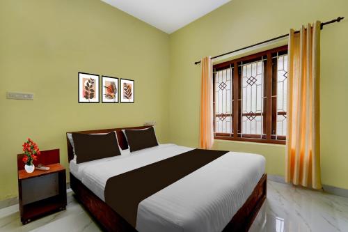 a bedroom with a large bed and a window at Hotel O NIMS Hospital Formerly White Castle in Bālarāmpuram