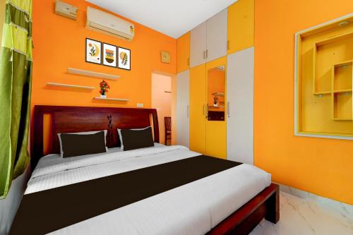 a bedroom with a large bed with orange walls at Hotel O NIMS Hospital Formerly White Castle in Bālarāmpuram