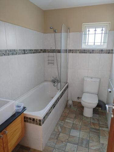a bathroom with a tub and a toilet and a sink at Lacaz Vacances in Tamarin