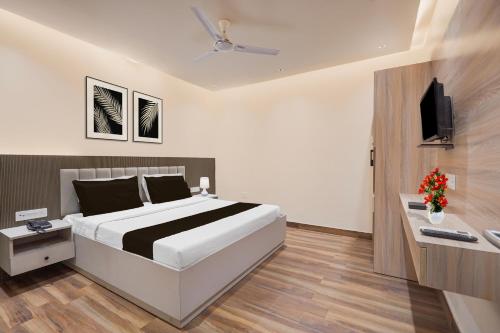a bedroom with a large bed and a television at Super Hotel O Rudrapur Railway Junction Formerly Krish in Rudrapur