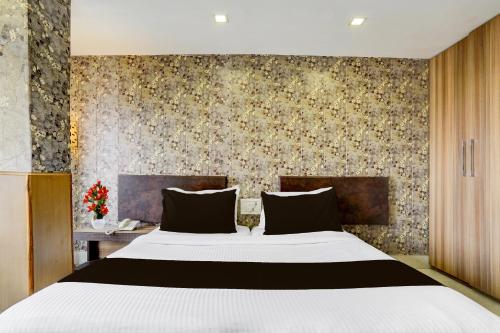 a bedroom with a large bed and a wall at Super Townhouse Oak ONGC Crossway Formerly Hotel Gold Stone Comfort in Dehradun