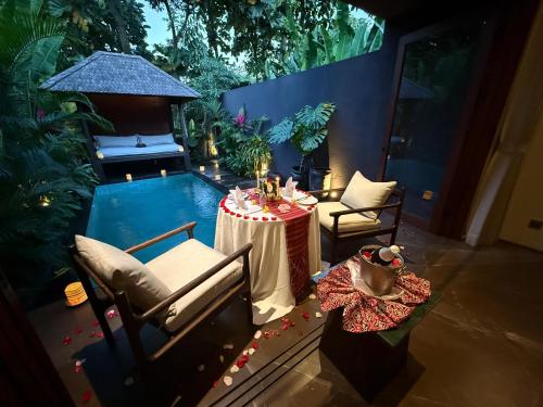 a patio with a table and a swimming pool at Mayaloka Villas Ubud in Ubud