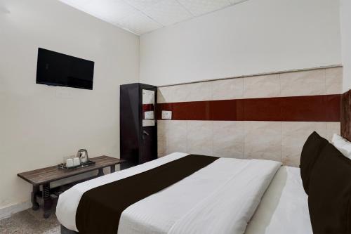 a bedroom with a bed and a tv on the wall at Townhouse Johri Enclave Metro Station Formerly Second Home in New Delhi
