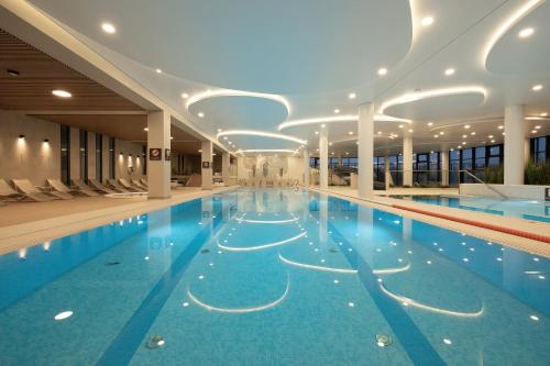 ein großes Schwimmbad in einem Gebäude in der Unterkunft Polanki Aqua Stylowy Apartament 300 m od Plaży by Noclegi Renters in Radzikowo
