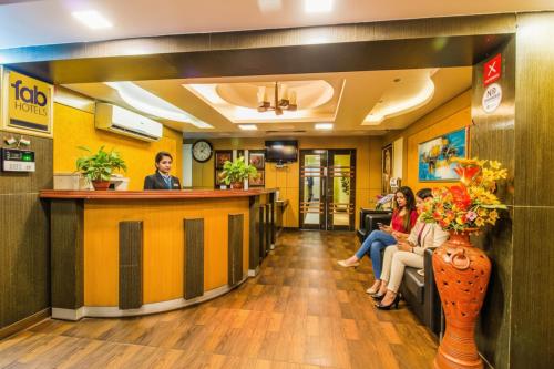 Un vestíbulo de un hospital con gente sentada en un bar. en FabHotel Palash Residency Ranchi Railway Station, en Ranchi
