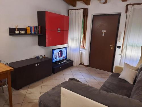 ヴェローナにあるLa casa di Davide con giardino e garageのソファとテレビのあるリビングルーム