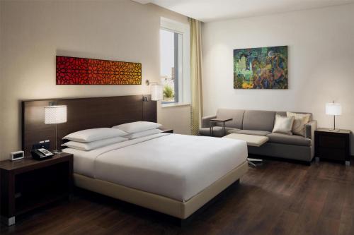 a hotel room with a bed and a couch at Hyatt Place Riyadh Sulaimania in Riyadh