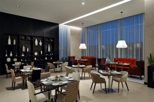a restaurant with tables and chairs in a room at Hyatt Place Riyadh Sulaimania in Riyadh