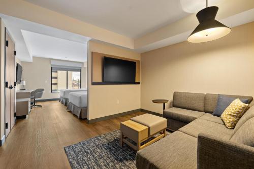 a living room with a couch and a bed at Hyatt Place Rapid City/Downtown in Rapid City