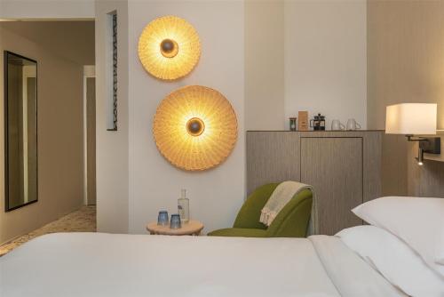 a bedroom with a bed and two mirrors on the wall at FirstName Toulouse, part of JdV by Hyatt in Toulouse