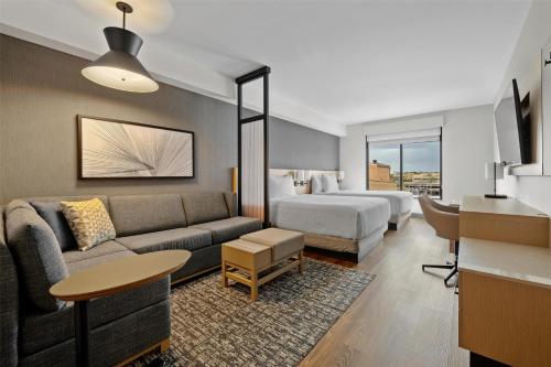 a hotel room with a bed and a living room at Hyatt Place Rapid City/Downtown in Rapid City