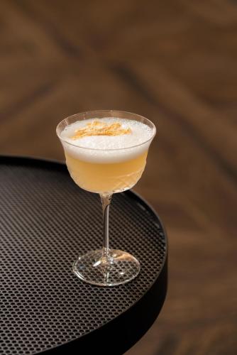 a drink in a martini glass sitting on a table at FirstName Toulouse, part of JdV by Hyatt in Toulouse