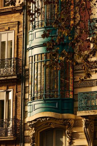 a building with a balcony on the side of it at FirstName Toulouse, part of JdV by Hyatt in Toulouse