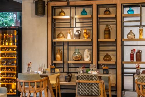 a room with a table and some vases on shelves at FirstName Toulouse, part of JdV by Hyatt in Toulouse