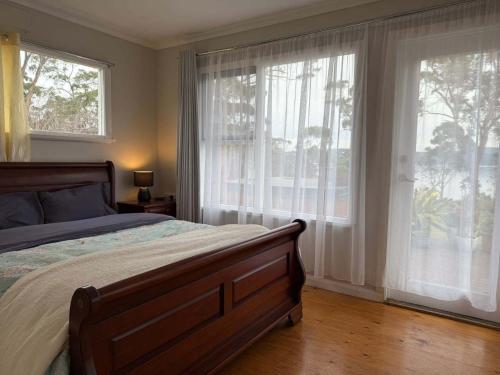 Un dormitorio con una cama y dos grandes ventanales. en The Seaside House - A little gem by the sea, en Tinderbox