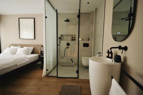 a bathroom with a shower and a sink and a bed at Like a therapy VILLA in Krčedin