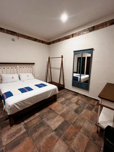 a bedroom with a bed and a mirror at Hotel Finca San José in Teotlalco
