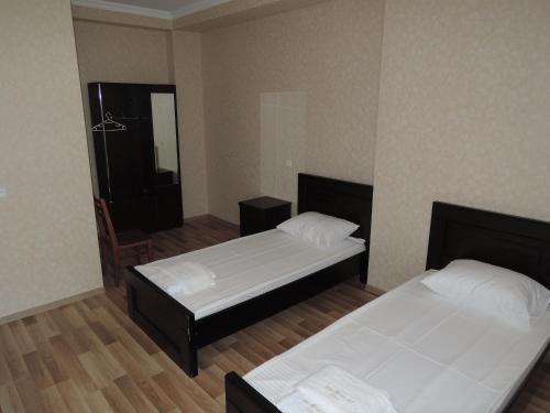 a room with two beds and a chair in it at Shaloshvili's Cellar Hotel in Shilda