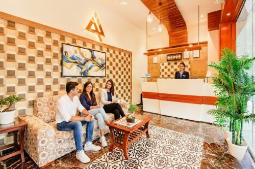 a group of people sitting on a couch in a waiting room at FabHotel Axis International - Nr Mumbai International Airport in Mumbai