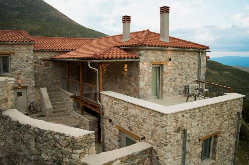 a stone house with a balcony on a mountain at Arxontiko Taygeti in Mystras