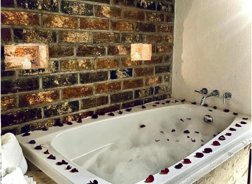 a white bath tub in a bathroom with a brick wall at Hotel Finca San José in Teotlalco