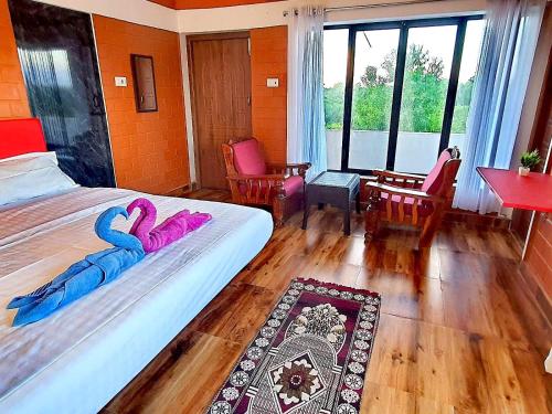 a bedroom with two beds with purple towels on them at Abaca AuroVibe in Kuilapayam