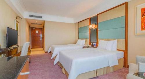 a hotel room with two beds and a television at Linyi Blue Horizon Intenational Hotel in Linyi