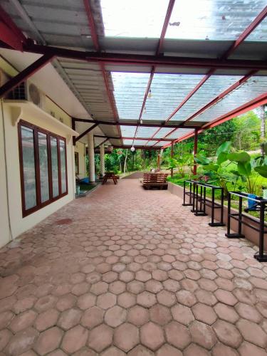 an open patio with a roof with tables and benches at VidFauw Oasis Villa in Naamlong
