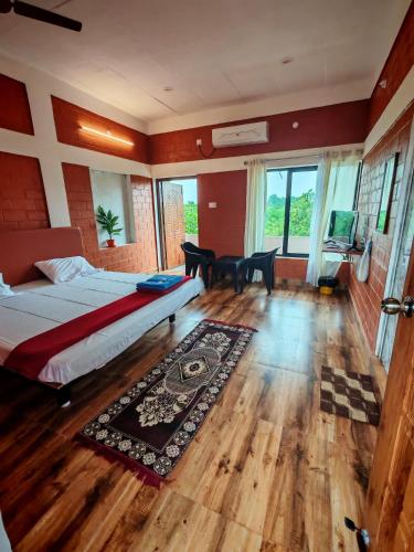 a bedroom with two beds and a table and chairs at Abaca AuroVibe in Kuilapayam